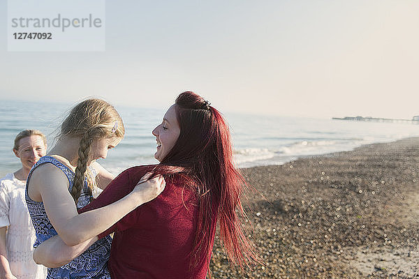Lesbian couple and daughter on sunny beach