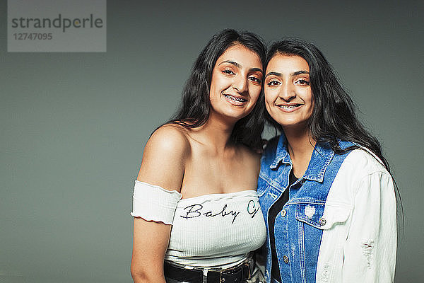 Portrait smiling  confident twin teenage sisters