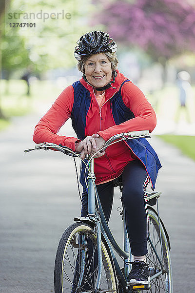 Portrait smiling  confident active senior woman riding bike in park