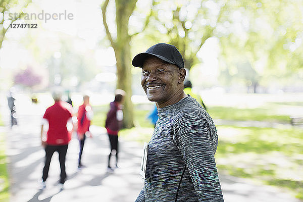 Portrait confident  happy senior man walking sports race in park