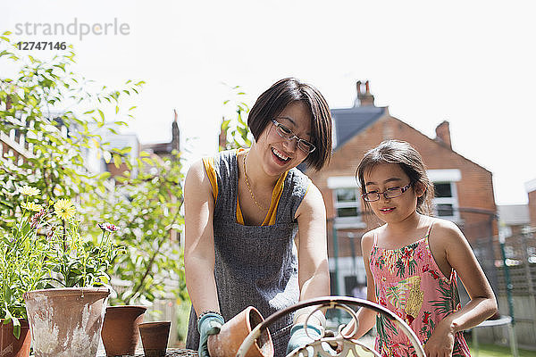 Mother and daughter gardening in sunny yard