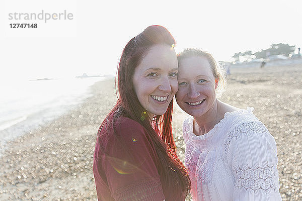 Portrait smiling  affectionate lesbian couple on sunny beach