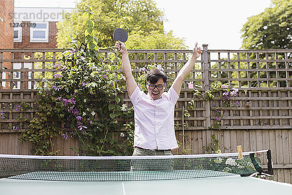 Exuberant man playing table tennis  celebrating