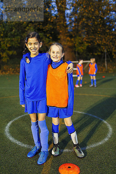 Portrait lächelnde  selbstbewusste Mädchenfußballerinnen