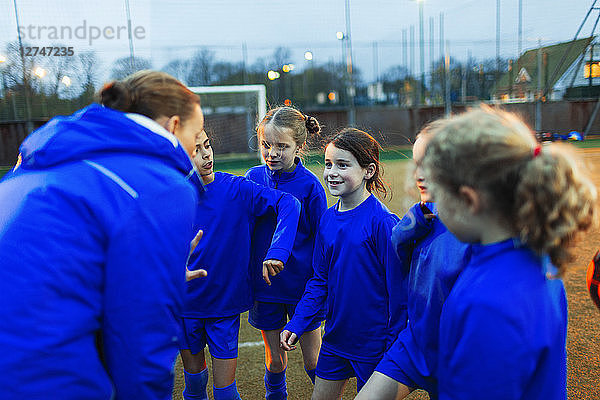 Mädchen-Fußballteam hört dem Trainer im Huddle zu