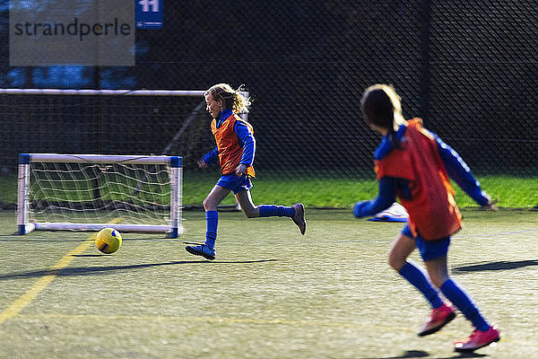 Mädchen laufen  spielen Fußball auf dem Feld