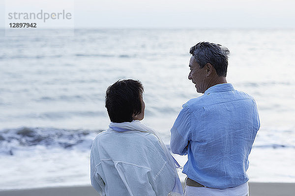 Japanisches Seniorenpaar amüsiert sich am Meer