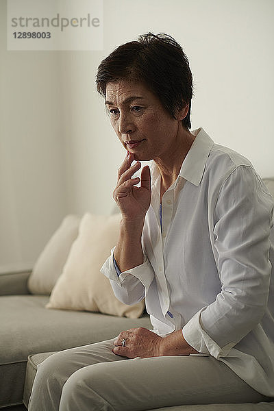 Japanische Seniorin auf dem Sofa
