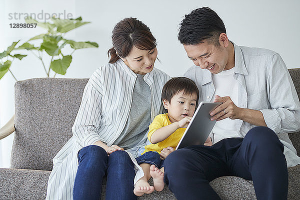 Japanische Familie auf dem Sofa