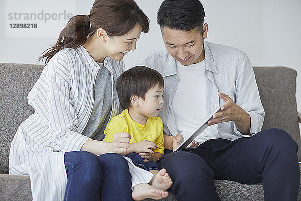 Japanische Familie auf dem Sofa