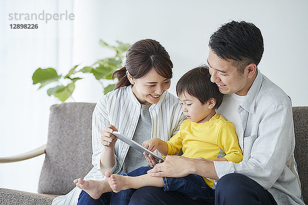 Japanische Familie auf dem Sofa