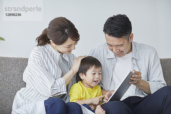 Japanische Familie auf dem Sofa