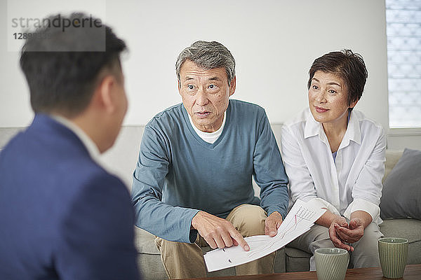 Japanisches Seniorenpaar im Gespräch mit Berater