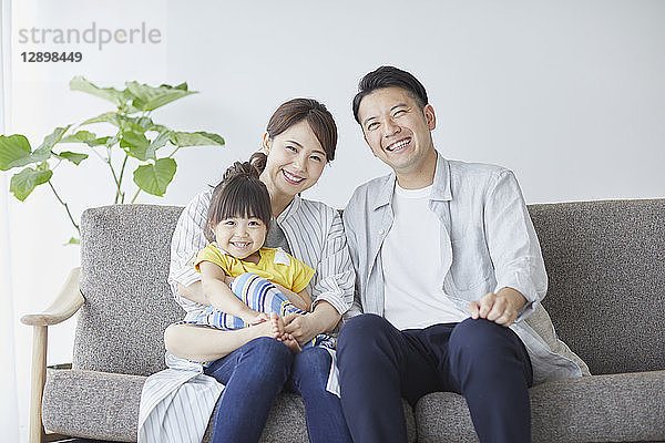 Japanische Familie auf dem Sofa