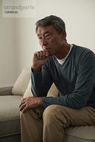 Japanischer älterer Mann auf dem Sofa