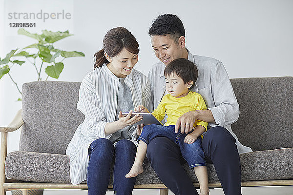 Japanische Familie auf dem Sofa