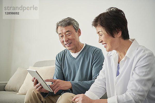 Japanisches Seniorenpaar auf dem Sofa