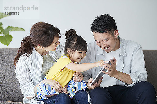 Japanische Familie auf dem Sofa