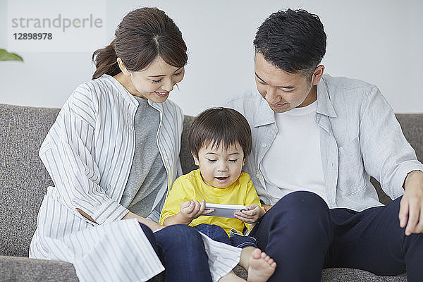 Japanische Familie auf dem Sofa