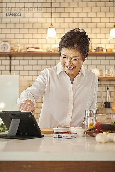 Japanische Seniorin in der Küche