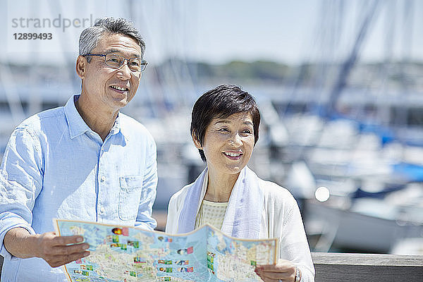 Japanisches Seniorenpaar amüsiert sich am Meer