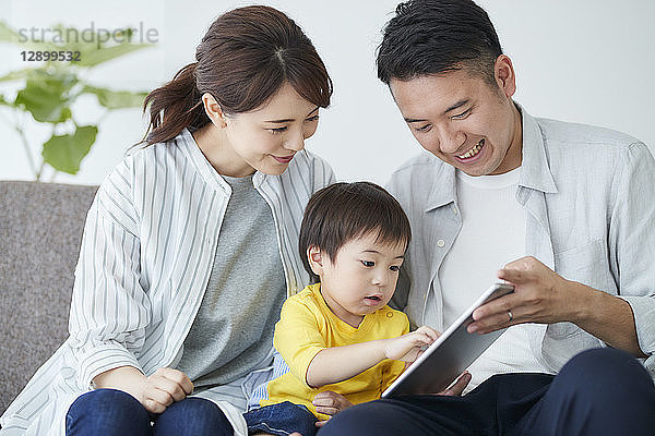 Japanische Familie auf dem Sofa