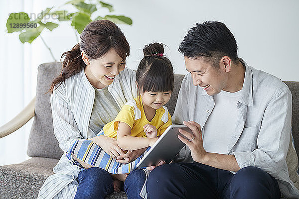 Japanische Familie auf dem Sofa