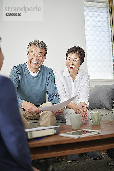 Japanisches Seniorenpaar im Gespräch mit Berater
