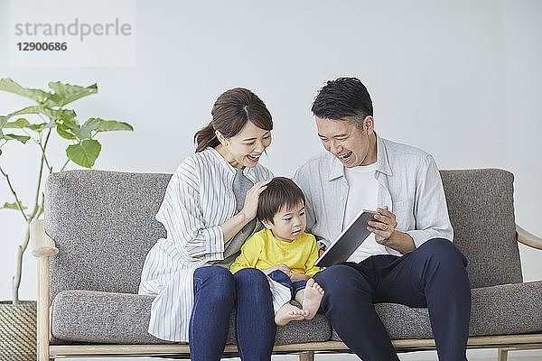 Japanische Familie auf dem Sofa