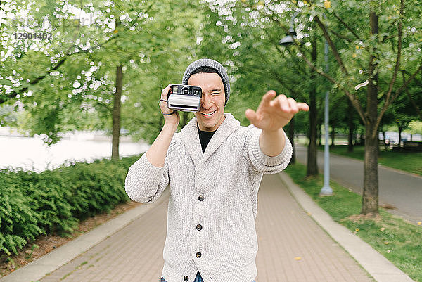 Junger Mann beim Fotografieren mit Sofortbildkamera  Vancouver  Kanada