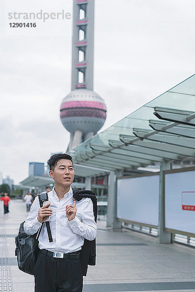 Junger Geschäftsmann schlendert durch die Stadt  Shanghai  China