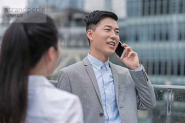 Junge Geschäftsfrau und Mann sprechen über Smartphone in der Stadt  Shanghai  China