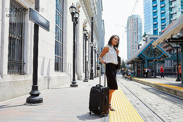 Geschäftsfrau wartet auf Stadtbahnsteig