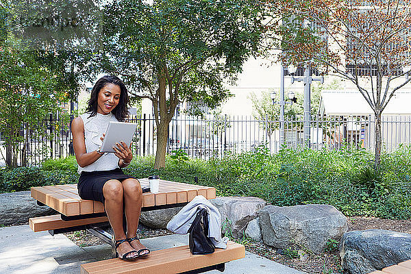 Geschäftsfrau benutzt digitales Tablet im Park