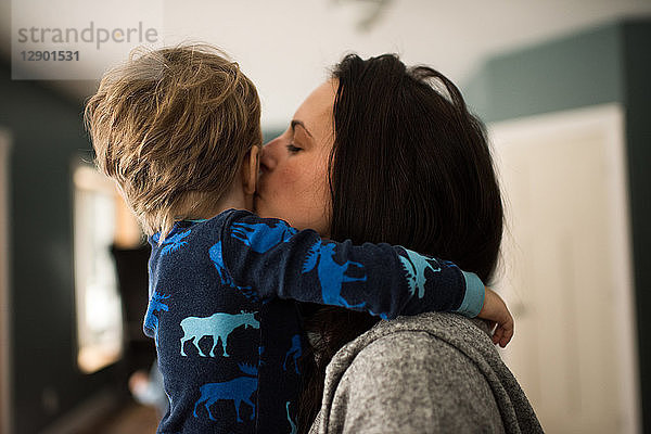 Mutter umarmt und küsst Sohn