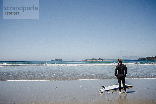 Mann mit Surfbrett am Strand  Tofino  Kanada