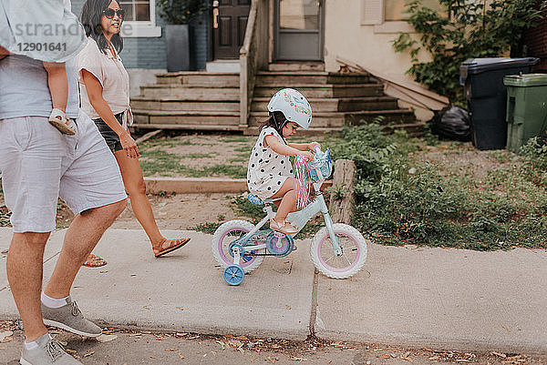 Familie zu Fuss mit Tochter auf Dreirad