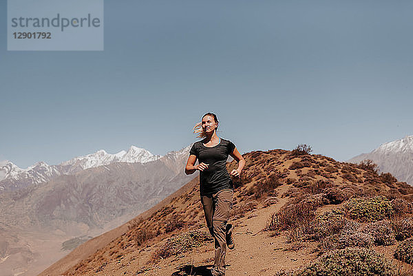 Frau joggt vom Gipfel herunter  Annapurna Circuit  Himalaya  Muktinath  Nepal