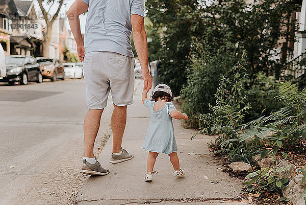 Mann mit Kleinkind-Tochter auf der Straße
