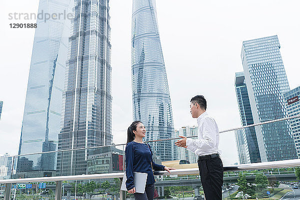 Junge Geschäftsfrau und Mann unterhalten sich im Finanzbezirk der Stadt  Shanghai  China