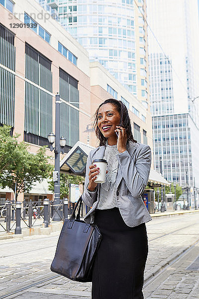 Geschäftsfrau benutzt Mobiltelefon auf der Straße
