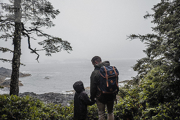 Vater und Kind schauen aufs Meer hinaus  Tofino  Kanada