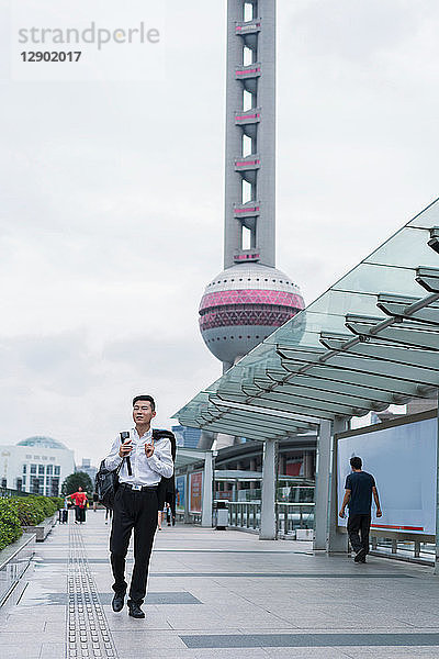 Junger Geschäftsmann schlendert durch die Stadt  Shanghai  China