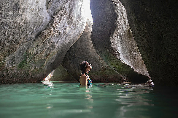 Junge Frau erkundet überschwemmte Grotte  Virgin Gorda  Britische Jungferninseln