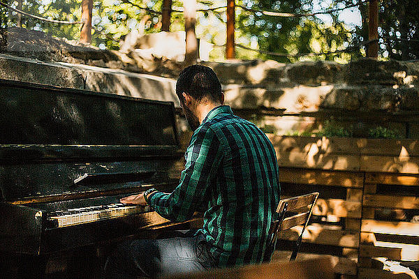 Mann spielt Klavier im Park