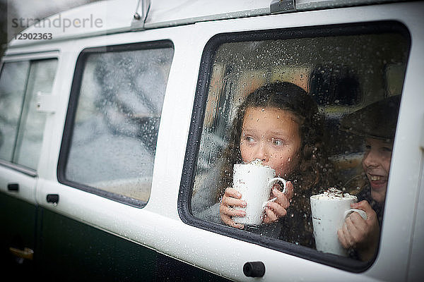 Mädchen trinken heiße Schokolade im Wohnmobil