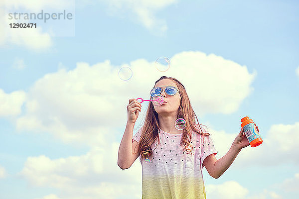 Mädchen spielt mit Seifenblasen