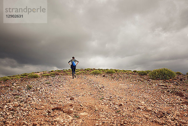 Frau wandert auf Feldweg den Berg hinauf  Rückansicht  Las Palmas  Gran Canaria  Kanarische Inseln  Spanien