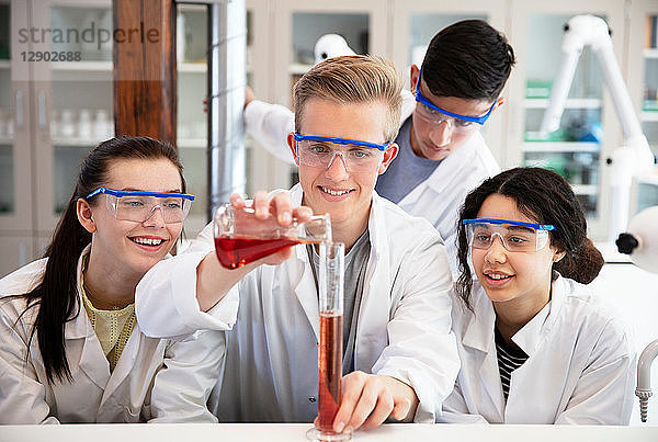 Schüler gießen im Labor eine Probe in einen Kolben