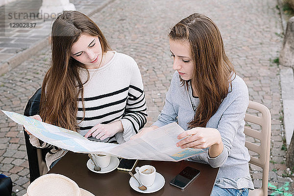 Freundinnen lesen Straßenkarte im Café